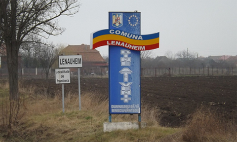 The village of Lanauheim, settled by German colonists in the late 18th century; The Germanic place name contrasts with the Latin-based Romanian welcome sign.
