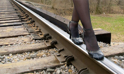 Alison Stine cover photo on Facebook. She's standing on railroad tracks.