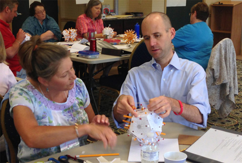 During a gathering of the Southeast Ohio Math Teachers' Circle, Bob Klein works with Laurie Campitelli from East Elementary School in Athens to assemble a "pencilcosa," a dodecahedron made of pencils and rubber bands.