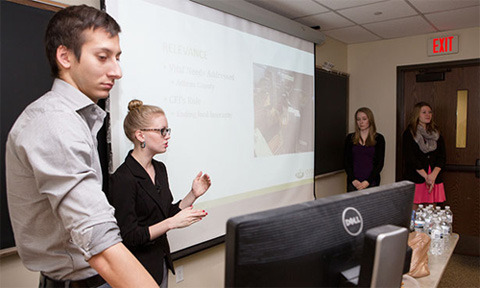 Economics of Altruism students (from left) Noah Rosenblatt, Kate Clausen, Maggie Harrison and Haley Trottier lead a presentation about Community Food Initiatives, and explain why the non-profit organization was chosen to receive $10,000 from the Learning By Giving Foundation.  Students (from left) Noah Rosenblatt, Kate Clausen, Maggie Harrison and Haley Trottier lead a presentation about Community Food Initiatives, and explain why the non-profit organization was chosen to receive $10,000 from the Learning by Giving Foundation.  Photographer: Lauren Pond/Ohio University