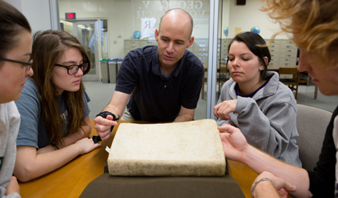 Clockwise, from left: Ohio University students Chloe Farmer, Michele Post, Brittany Centorbi, and Josh Davis, as well as Associate Professor Bob Klein, center, examine an ancient math text during a special presentation at Alden Library on April 18, 2014. During the presentation, students enrolled in Professor Klein's History of Mathematics course viewed some of the centuries-old math manuscripts that are stored in the library's Special Collections section. Photo by Lauren Pond 