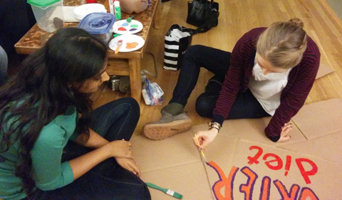 Graduate students Shelby Martin and Akanksha Srivastav create the title sign for the lab's pumpkin display.