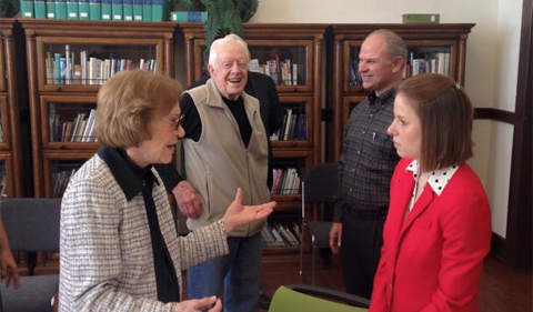 History graduate student Eryn Kane (in red) talks with Rosalynn Carter, as President Carter looks on.