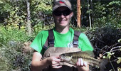 Jackie (Smith) Kloepfer holding a small mouth bass in Sharps Fork, a tributary of Federal Creek, in Athens County. "I was helping with a water quality monitoring project, one of many that ODNR-DMRM performs every year in various watersheds across southeast Ohio.