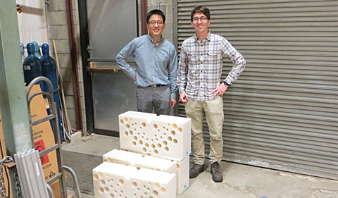 Nuclear Physicists Tony Ahn and Zach Meisel stand on the dock at the Edwards Accelerator Lab and behind section of the polyethylene blocks used to slow down neutrons. The holes are where the detectors are placed. Dr. Tony Ahn and Dr. Zach Meisel stand on the dock at the Edwards Accelerator Lab and behind section of the polyethylene blocks used to slow down neutrons. The holes are where the detectors are placed.