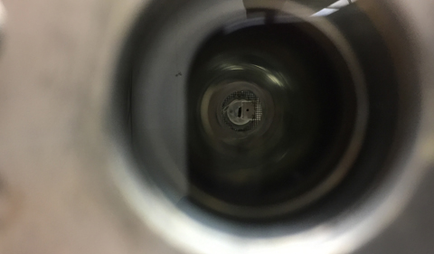 From the end of the scattering chamber, looking in, one can see the Ohio silicon detector’s small circular aperture toward the right, and the rectangular-collimated beamline where the protons enter in the center.
