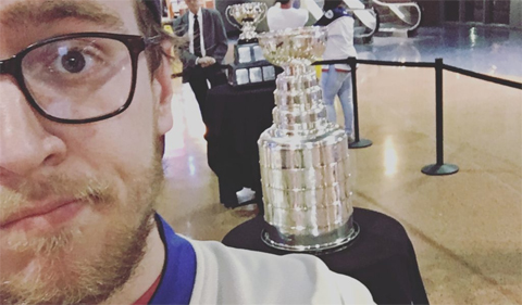 Graduate student Sean Merz has found success as a writer for Last Word on Sports. Pictured here with Stanley Cup in background and wearing a Columbus Blue Jackets sweater.