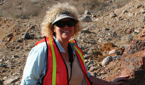 Dr. Cathy Busby, photo taken outside with rocky background