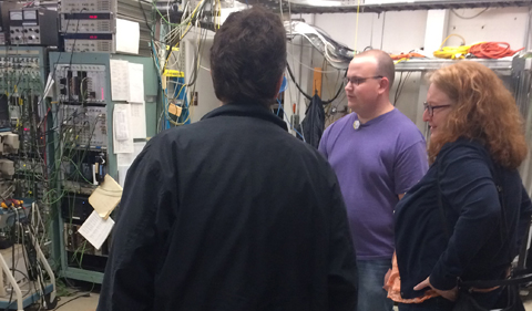 Graduate student Tyler Danley and visitors stop in the control room at the accelerator.
