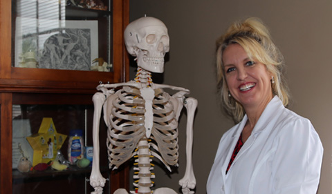 Dr. Jodie Foster, in lab, with skeleton and white coat