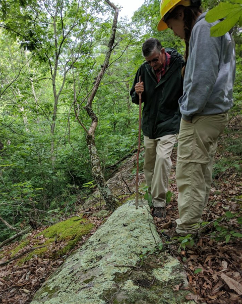 Ray Showman and Emily Penn observing lichens on a rock. 
