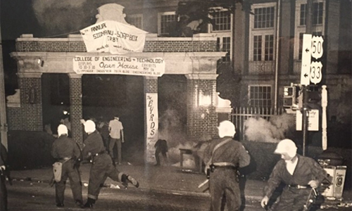 Student protests at entrance to Ohio University in 1970, with police in riot gear and fire burning in trash can