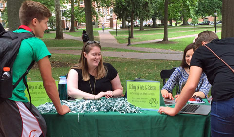 Advisers Stevi Miller and Tetyana Dovbnya help students at "Advising on the Green." Table is outside on teh green.