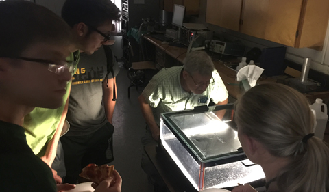 Dr. Thomas Massey demonstrates the tracks of cosmic rays as they pass through a cloud chamber. 