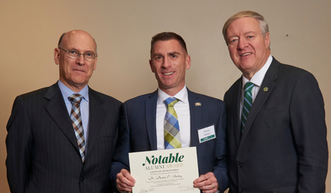 From left, College of Arts & Sciences Dean Robert Frank, alum Dustin Starkey, and President M. Duane Nellis, with Starkey holding Notables certificate.
