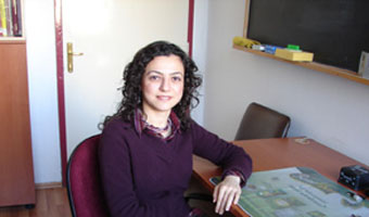Dr. Pınar Aydoğdu, sitting at desk