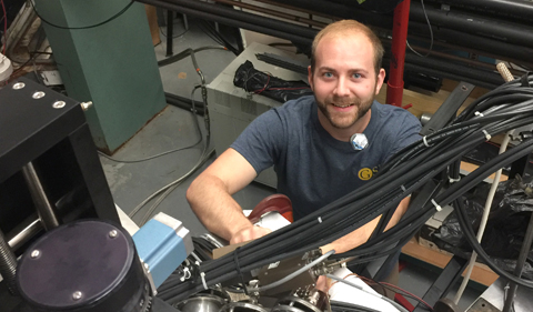 ND Doctoral Student Bryant Vande Kolk adds a pulser cable to a detector to test its time of flight signal.