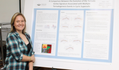 2015 Geography capstone poster presentation, photo showing woman standing with her poster.