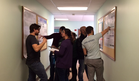 Scientific Writing poster session in Porter Hall, with students pointing at posters on both sides of hallway,