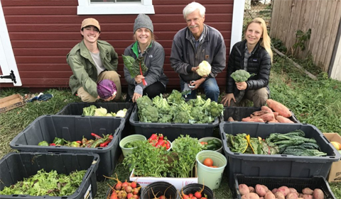 Dr. Art Trese and students at the Plant Biology Learning Gardens, shown with many bins of harvested fall vegetables