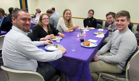 Delta Phi Alpha members, shown sitting around a table and eating.