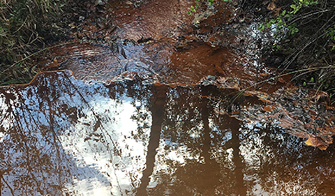 Acid Mine Drainage photo showing brown stains in stream.