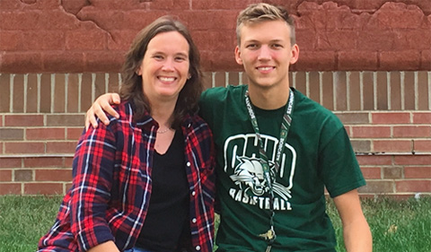 OHIO alum Michelle Collins and son Jacob Collins, current student in Geography, sitting on brick wall.