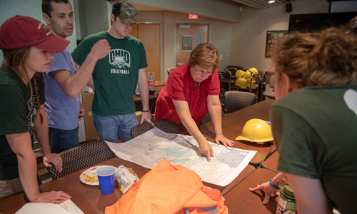 OHIO Associate Professor Dr. Viorel Popescu (blue shirt) and Lynda Andrews (red shirt) help train and coordinate Conservation Ecology Lab students working on research at the Wayne National Forest headquarters. Photo by Ben Siegel