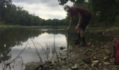 Lucas Howard collects a sediment sample along the Maumee River. Nutrient loads are examined in both the deposited sediment and water samples.