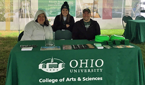 Students and staff welcome folks to the College of Arts & Sciences tent.