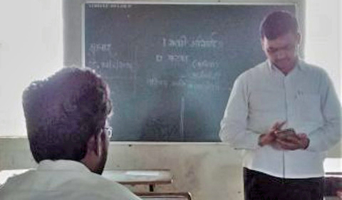 A teacher using his phone in class.
