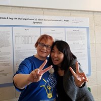 MC Augstkalns and Dr. Soomin Jwa pose for a photo in front of MC's poster