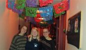 Three of Sigma Delta Pi's members pose under papel picado while decorating Gordy Hall for Día de los Muertos.