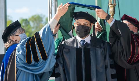 Ali Aldhumani gets hooded at graduate commencement at Ohio University 2021. 