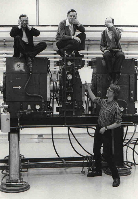 Roger Finlay, Jacobo Rapaport, and Steve Grimes, sitting on top of the newly-installed magnetic quadrupole triplet spectrometer in the large target room in the spring of 1979. Senior Honors Tutorial College student Jerry Weber is standing the foreground, asking the faculty for recommendation letters to graduate school.