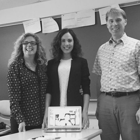 Alba García-Alonso celebrates defending her thesis, posing with two professors and a cake.