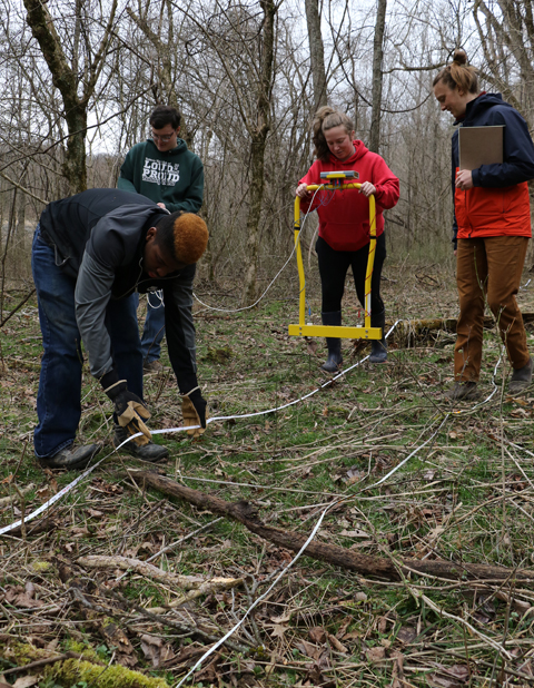 University of Pennsylvania Ph.D. Student Moriah McKenna, far right, trains Ohio University undergraduates, from left, Deontae Brown, Zach Lawson and Nellie Sullivan how to use a soil resistance meter to map underground features.